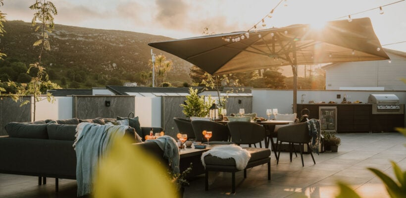 Outdoor dining and lounger area on a large decking with hillside views, and your very own outdoor kitchen at The Warren Resort & Spa